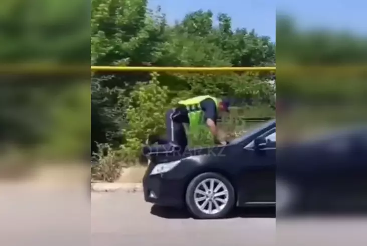 Полицейского провезли на капоте автомобиля в Шымкенте