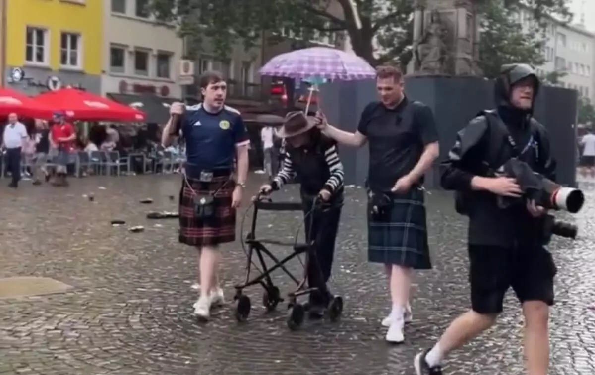 Болельщики могут быть милыми: на Евро шотландцы помогли прохожему не промокнуть
