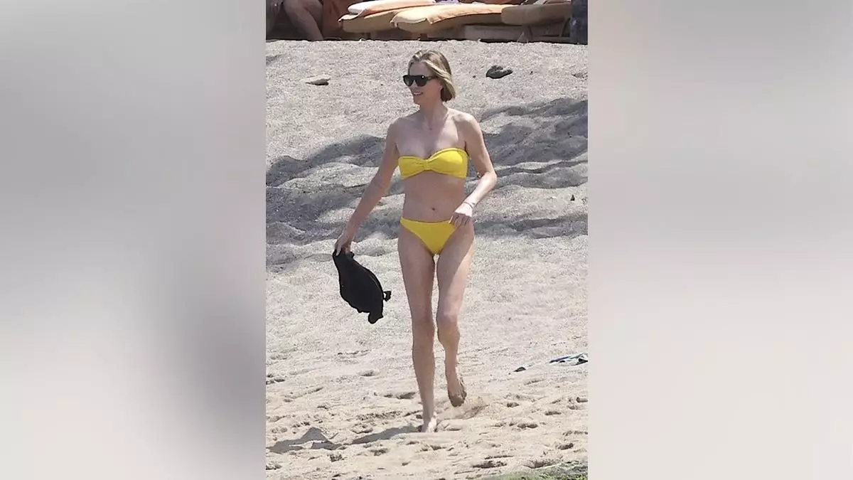 Шарлиз Терон поражает в желтом бикини во время пляжного отдыха на Гавайях с двумя дочерьми.