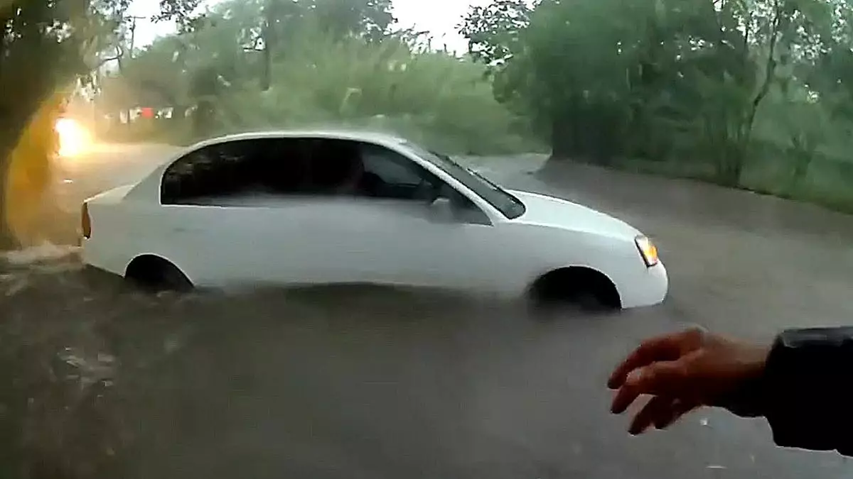 Ребенок извлечен из автомобиля, застрявшего в бушующем паводке, в ходе драматичного спасения, попавшего на видео.
